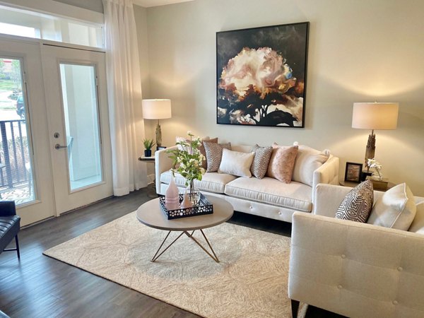 Contemporary living room with stylish furniture at The Peak at Nichols Plaza Apartments, showcasing upscale living in a prime location