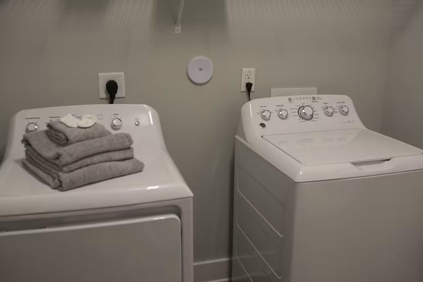 Laundry room with modern appliances at The Peak at Nichols Plaza Apartments