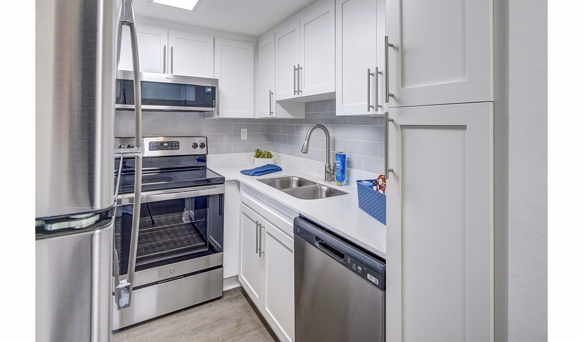 Modern kitchen with sleek appliances and granite countertops in 7 West Apartments