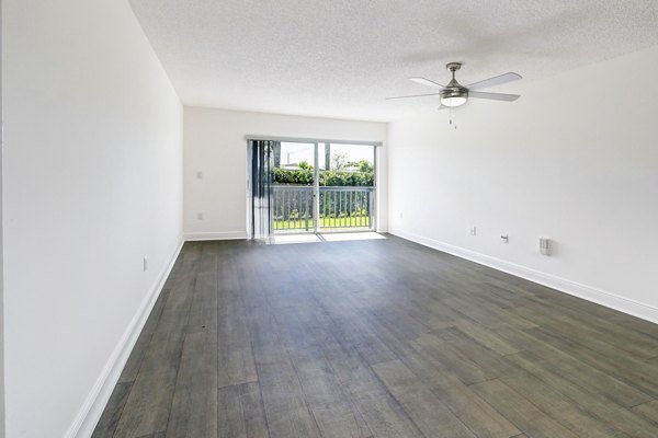 Modern living room with large windows and hardwood floors in 7 West Apartments, luxury Greystar property