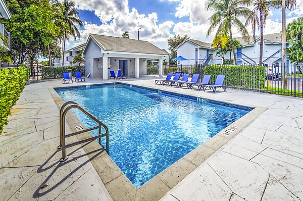Sunny outdoor pool area with comfy loungers at 7 West Apartments