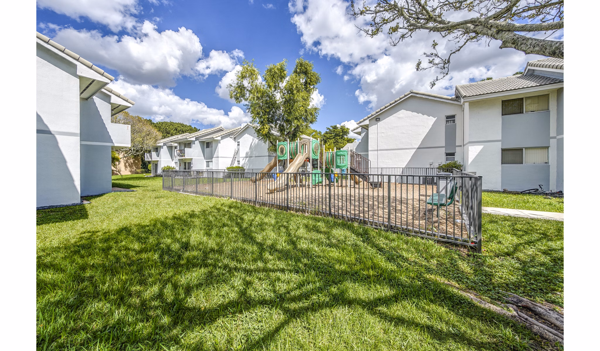 Playground area with modern equipment at 7 West Apartments, offering a safe and exciting space for children in a luxury community setting
