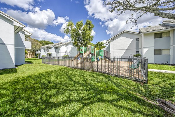 Playground area with modern equipment at 7 West Apartments, offering a safe and exciting space for children in a luxury community setting