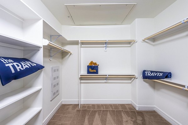 Elegant bedroom closet with custom shelving in The Travis Apartments