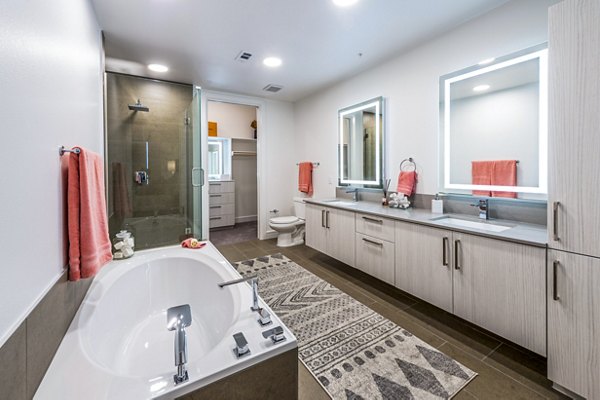 Modern bathroom featuring sleek fixtures and subway tile at The Travis Apartments