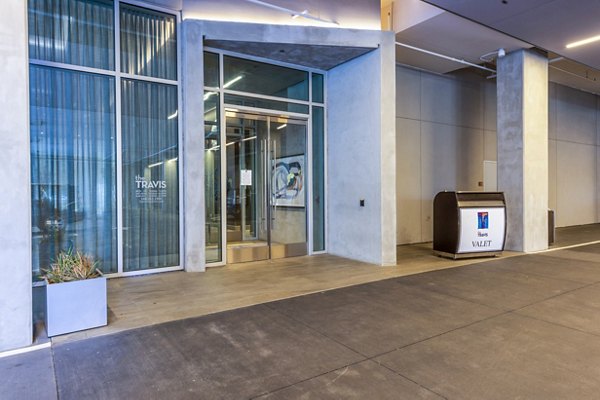 The Travis Apartments: Sleek clubhouse entrance with valet service, offering luxury living in downtown Austin