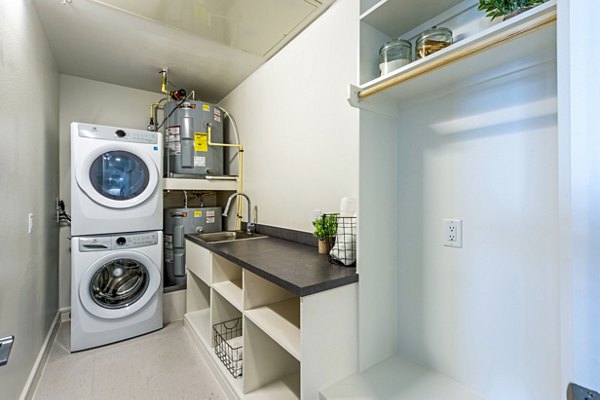 Laundry room with modern appliances and ample storage at The Travis Apartments, a luxury Greystar property in Austin, Texas