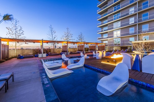 Inviting outdoor pool and modern fire pit at The Travis Apartments, offering luxury living in a prime location