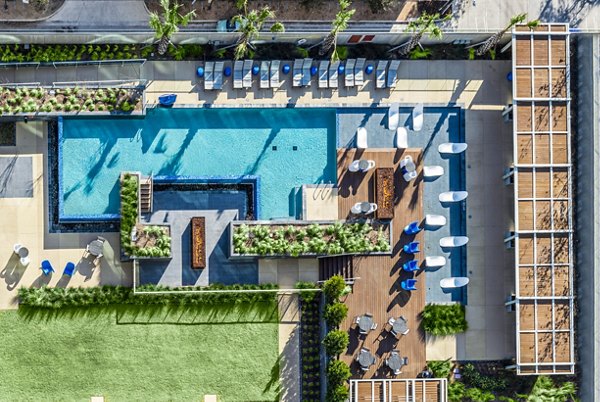 Relaxing pool with sun loungers at The Travis Apartments in luxury living environment