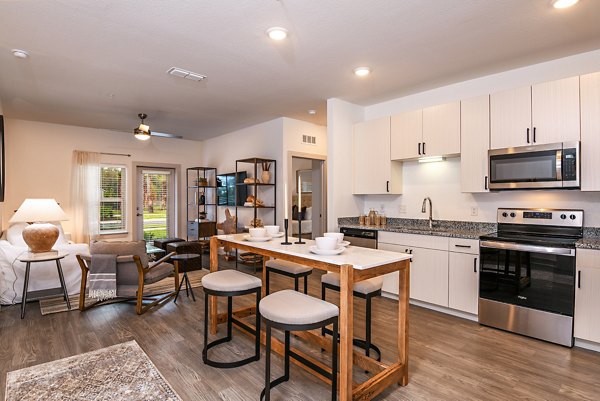 Modern kitchen with granite countertops and stainless steel appliances at Grand Cypress Apartments