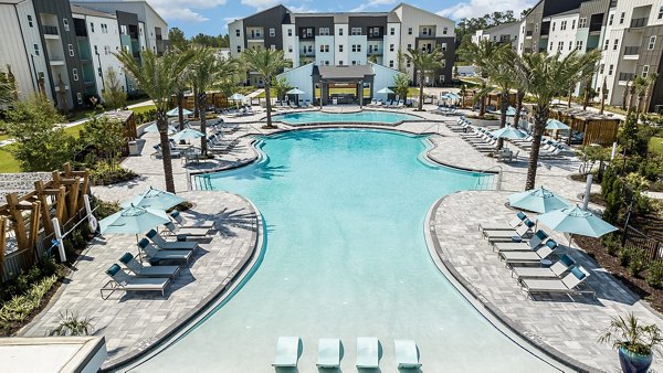 Resort-style pool at Grand Cypress Apartments, offering luxury living with ample poolside seating and lush landscaping