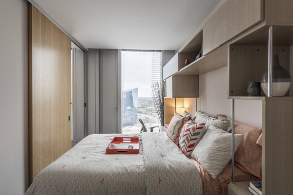 Bedroom with modern decor and large windows in Evo at Cira Centre South Apartments