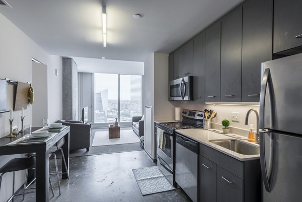 Modern kitchen with stainless steel appliances and sleek countertops at Evo at Cira Centre South Apartments