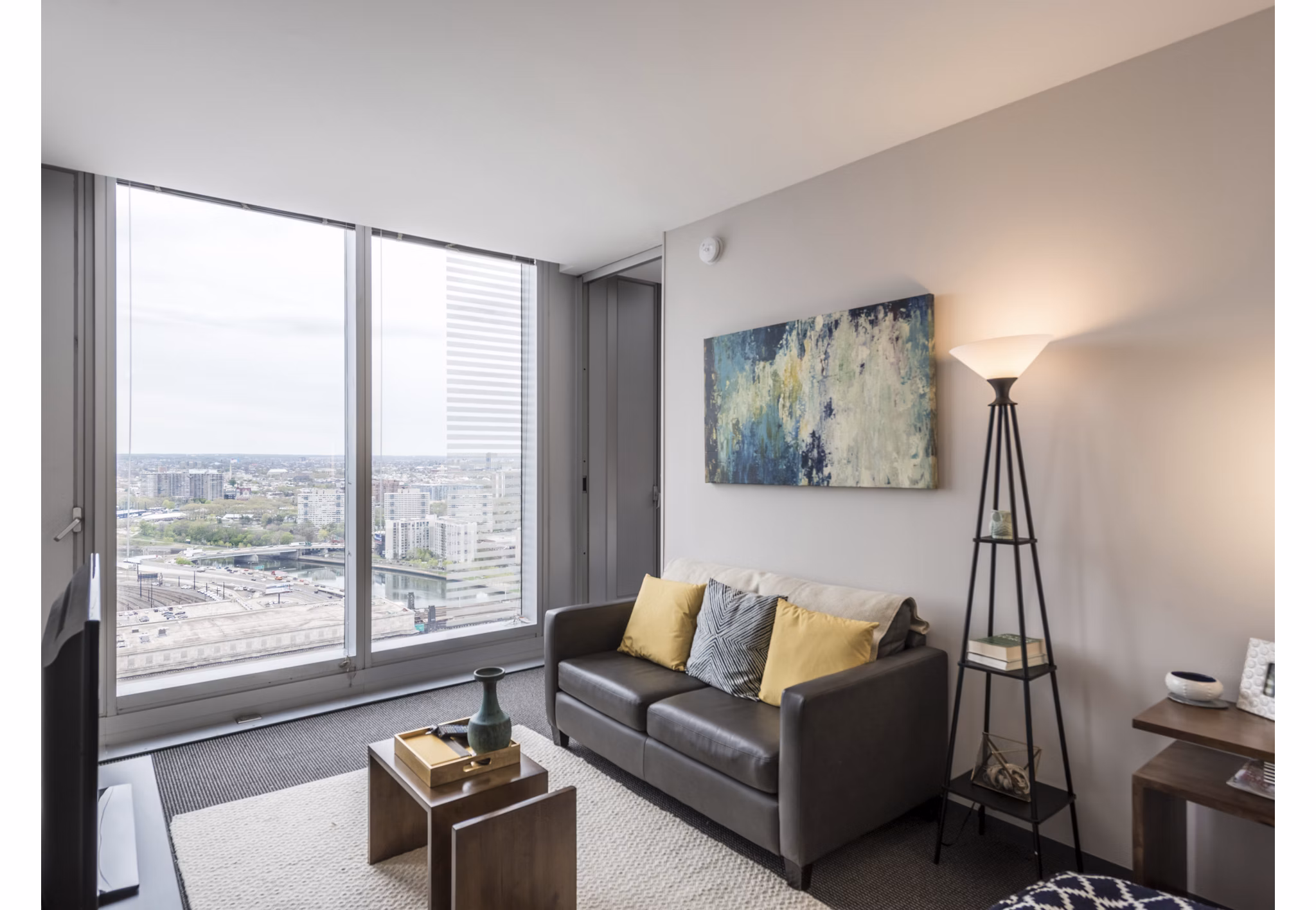 Spacious living room with sleek furnishings and city views at Evo at Cira Centre South Apartments