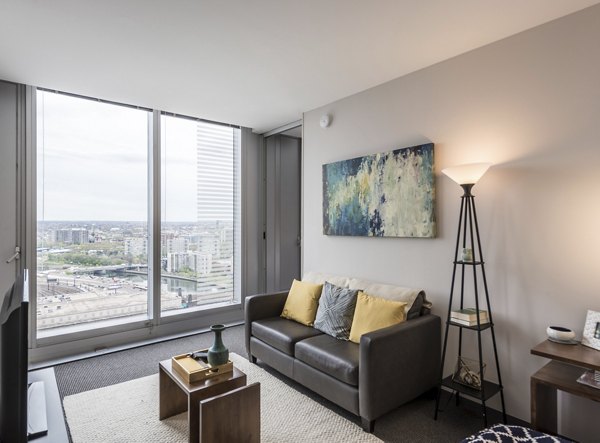 Spacious living room with sleek furnishings and city views at Evo at Cira Centre South Apartments