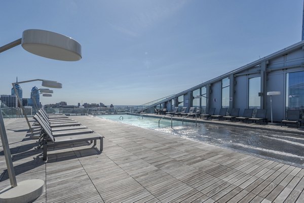 Modern swimming pool with lounge chairs at Bay Court at Harbour Pointe Apartments, a luxury Greystar community