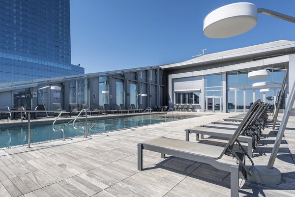 Pool surrounded by lush landscaping at Bay Court at Harbour Pointe Apartments, offering luxury living with resort-style amenities