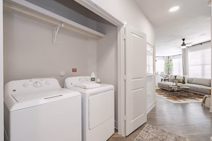 Laundry room with modern appliances and ample storage at The Lyric at Keller Center Stage Apartments