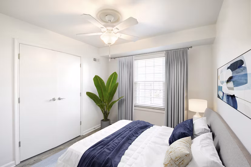 Cozy bedroom with modern decor at North Hill Apartments, featuring large windows and ample natural light