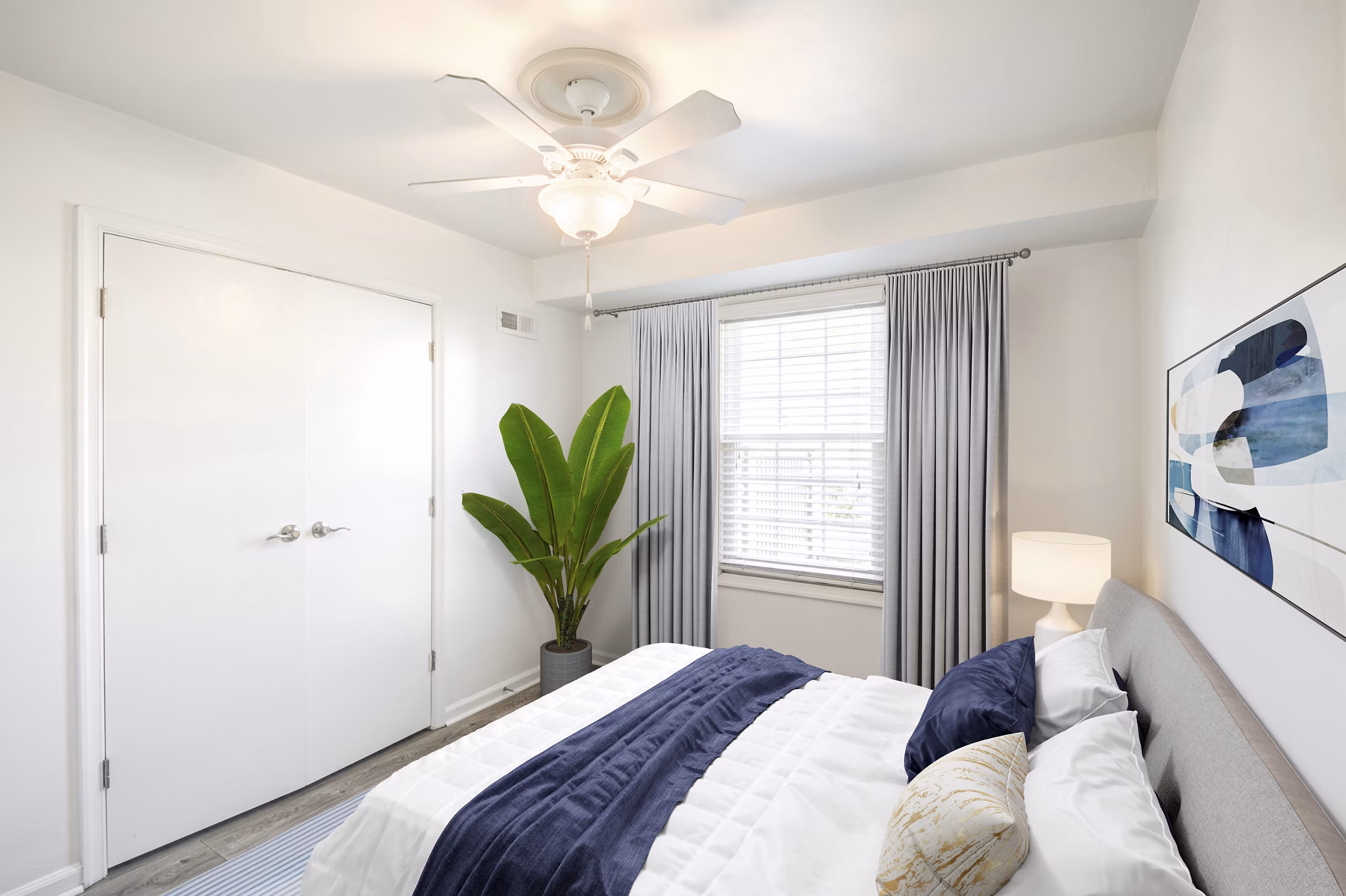 Cozy bedroom with modern decor at North Hill Apartments, featuring large windows and ample natural light