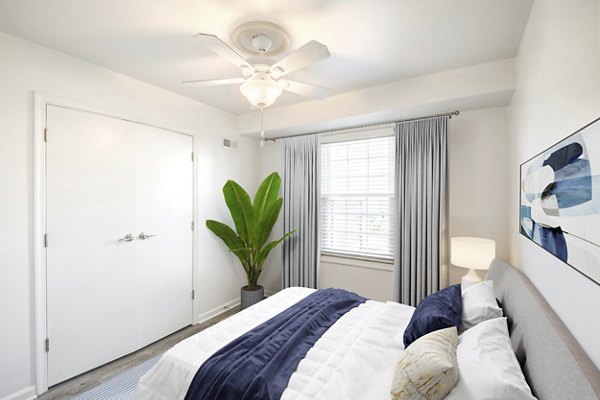 Cozy bedroom with modern decor at North Hill Apartments, featuring large windows and ample natural light