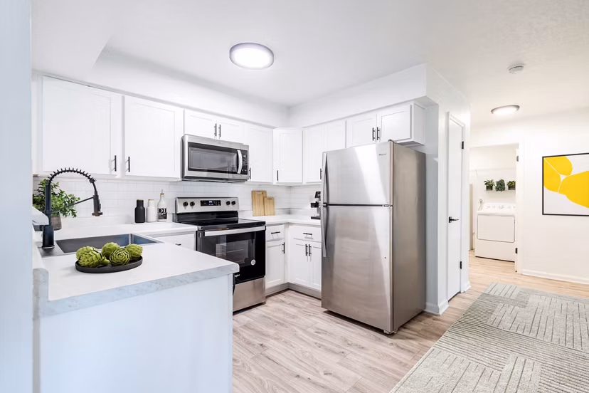 Kitchen featuring modern appliances and granite countertops in North Hill Apartments