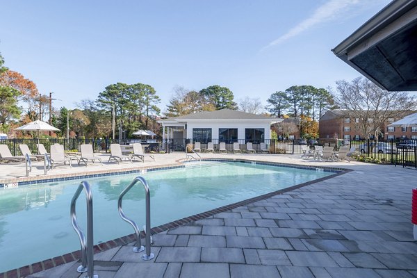 Outdoor pool with lounge chairs at North Hill Apartments
