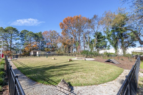 Fenced dog park with agility equipment at North Hill Apartments