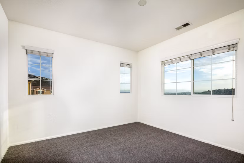 Cozy bedroom with contemporary decor at Jackson Pointe 111 Apartments, featuring plush bedding and natural light