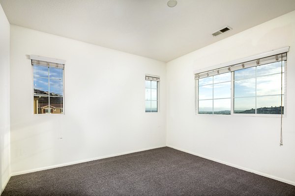 Cozy bedroom with contemporary decor at Jackson Pointe 111 Apartments, featuring plush bedding and natural light
