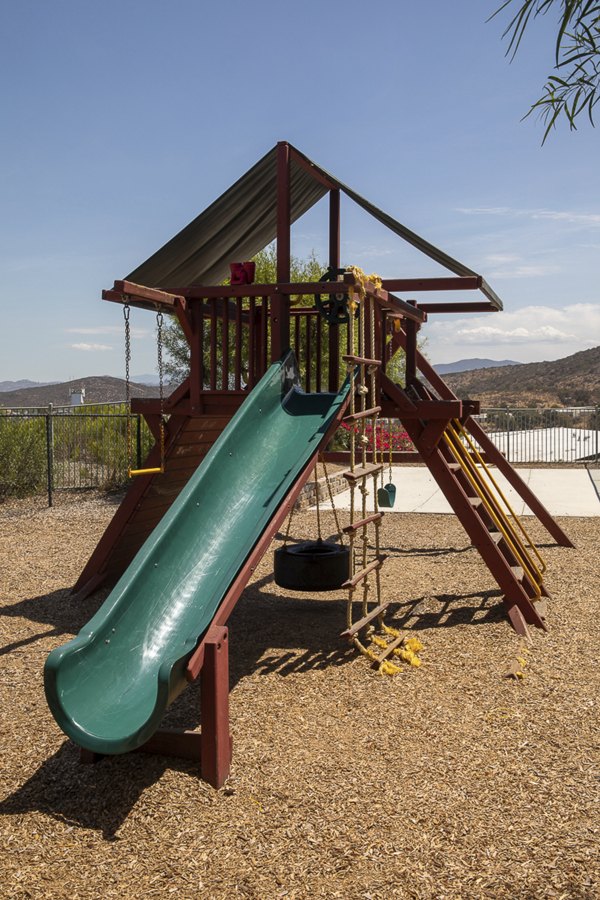 Kids playing on modern playground at Jackson Pointe 111 Apartments, a family-friendly space promoting outdoor activities and fun