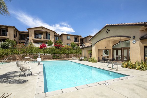 Sunlit pool surrounded by lounge chairs at Lakeview 88 Apartments, ideal for relaxation and leisure activities