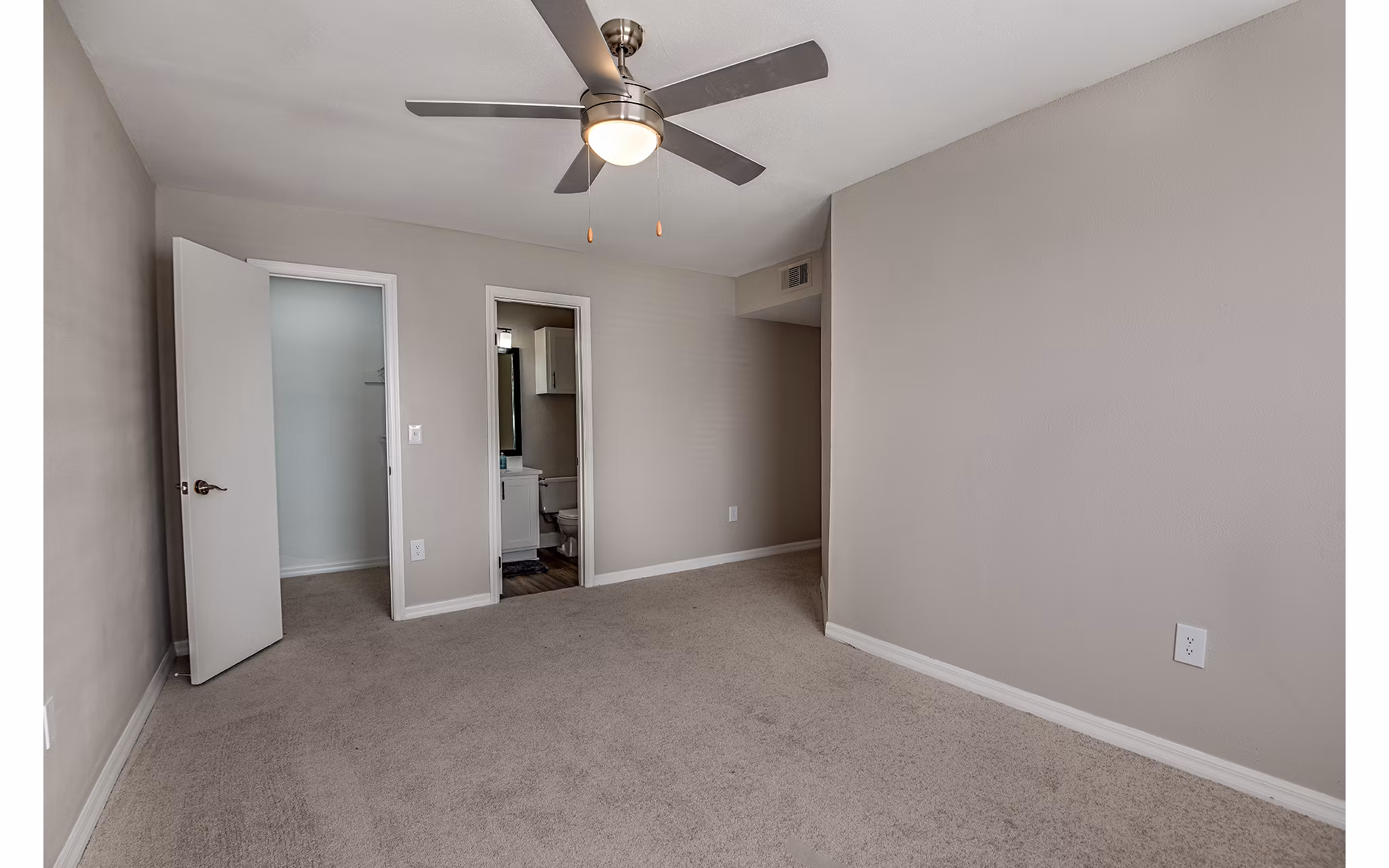 Cozy bedroom featuring plush bedding and large windows at Lake Pointe Apartments