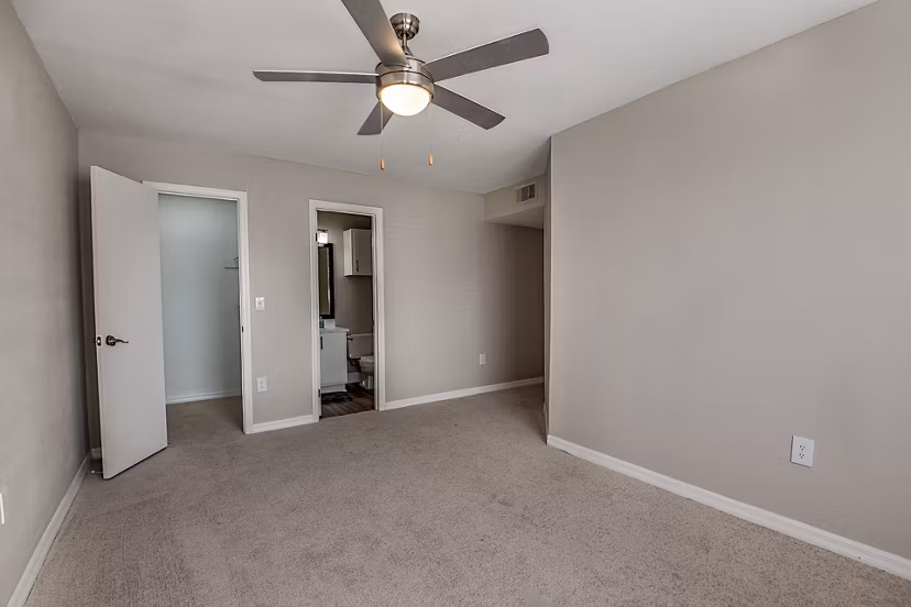 Cozy bedroom featuring plush bedding and large windows at Lake Pointe Apartments