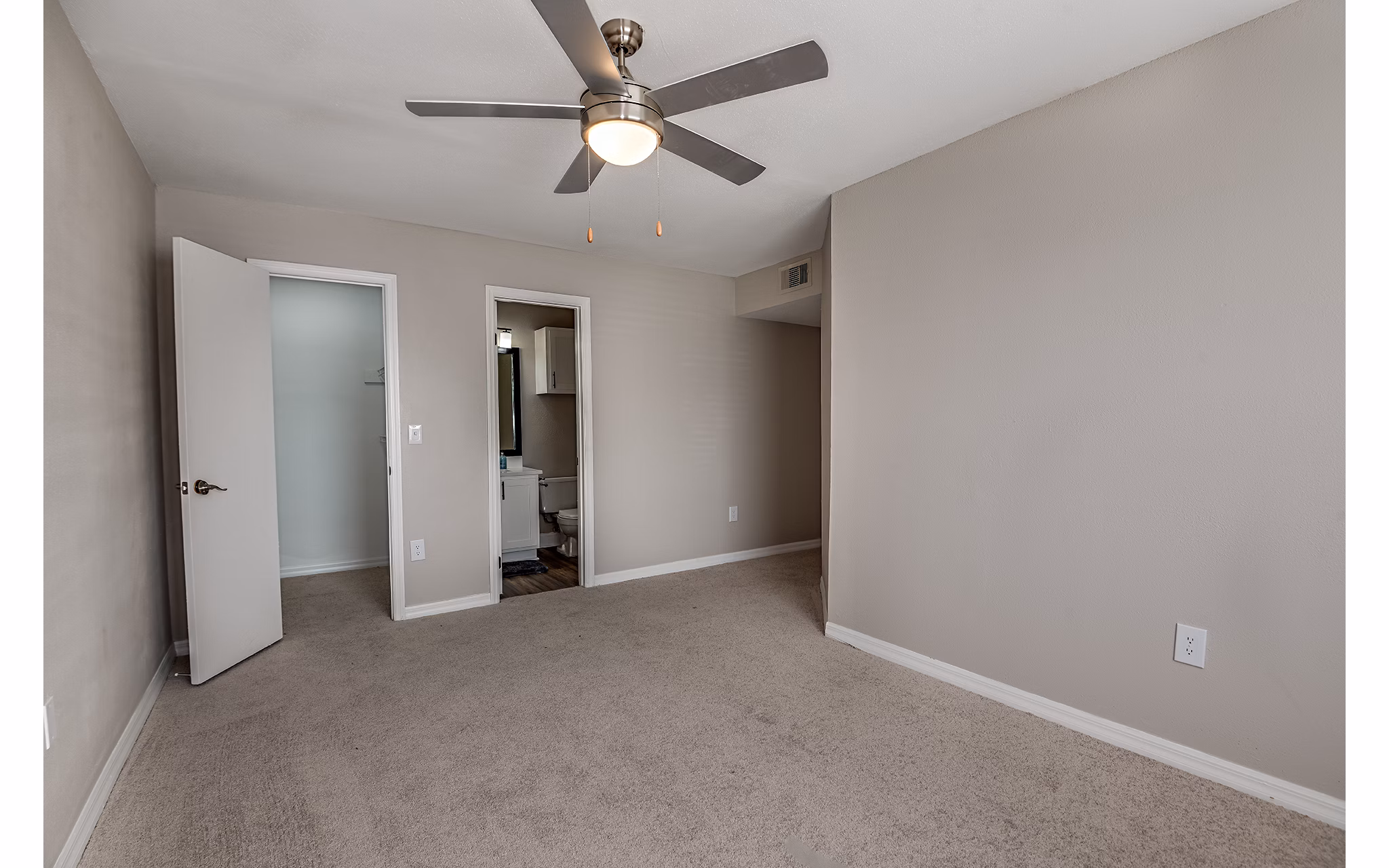 Cozy bedroom featuring plush bedding and large windows at Lake Pointe Apartments
