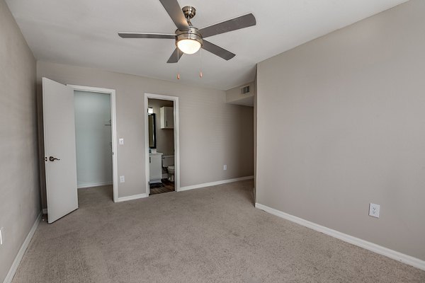 Cozy bedroom featuring plush bedding and large windows at Lake Pointe Apartments