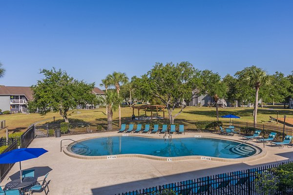 Sparkling pool with sun loungers at Lake Pointe Apartments offers relaxing outdoor space in this luxury community