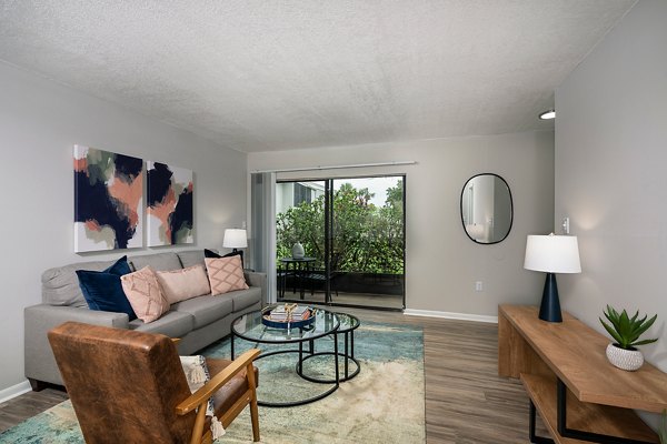 Spacious living room with modern decor and large windows at The Vinyards Apartments