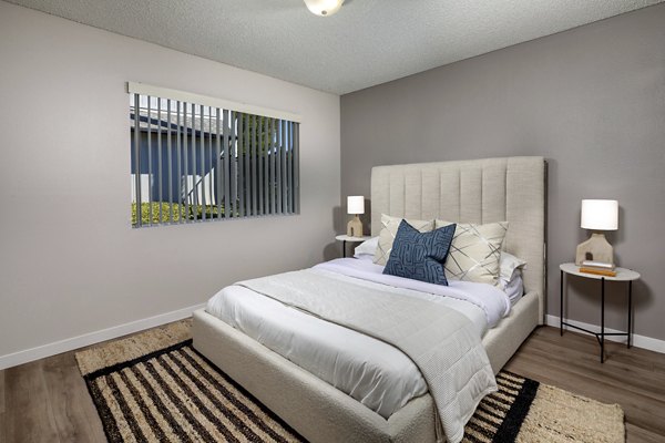 Bedroom featuring modern furnishings and natural light at Windscape Village Apartments in this Greystar community image