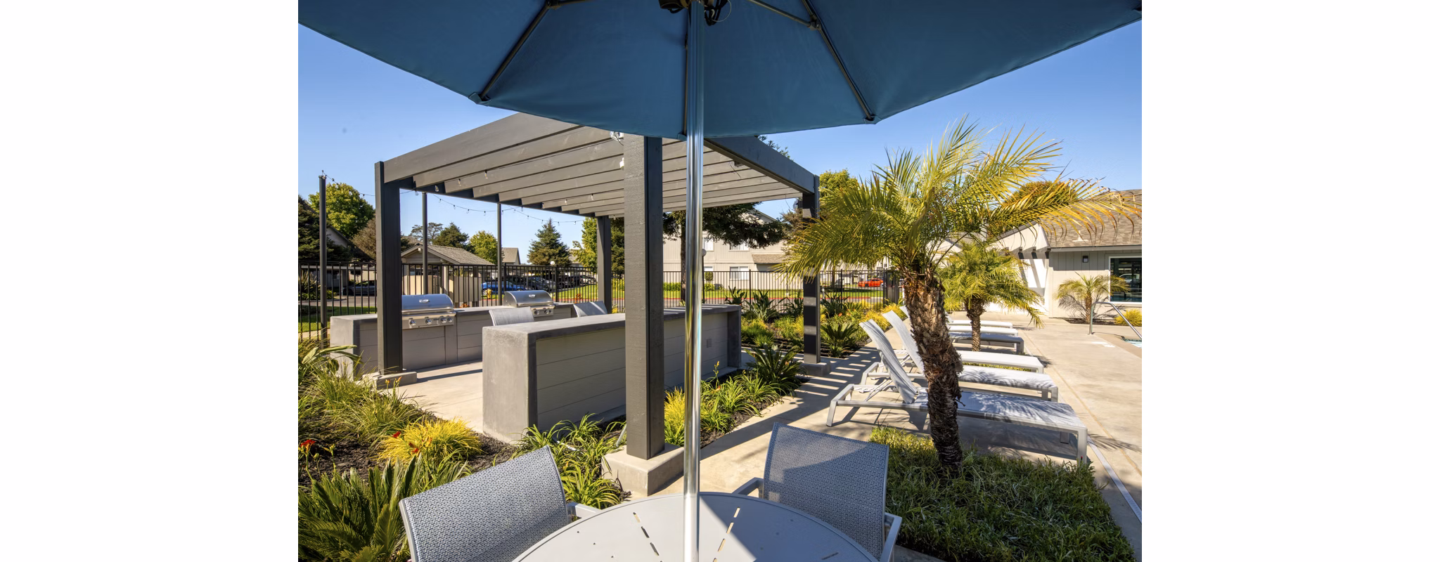 Grill area with seating and shade at Windscape Village Apartments