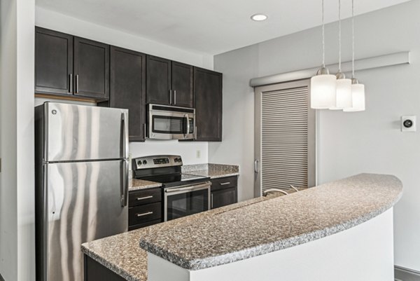 Modern kitchen with stainless steel appliances and granite countertops at Rivers Edge Apartments