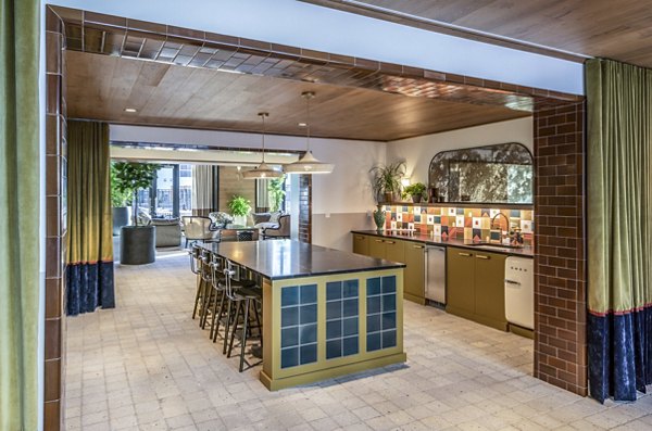 Spacious kitchen featuring an island, colorful backsplash, and dining area in The Lucie Apartments