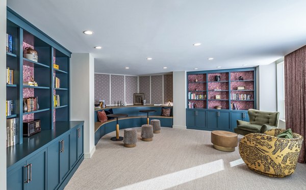Modern lounge with blue bookshelves and cozy seating at The Lucie Apartments