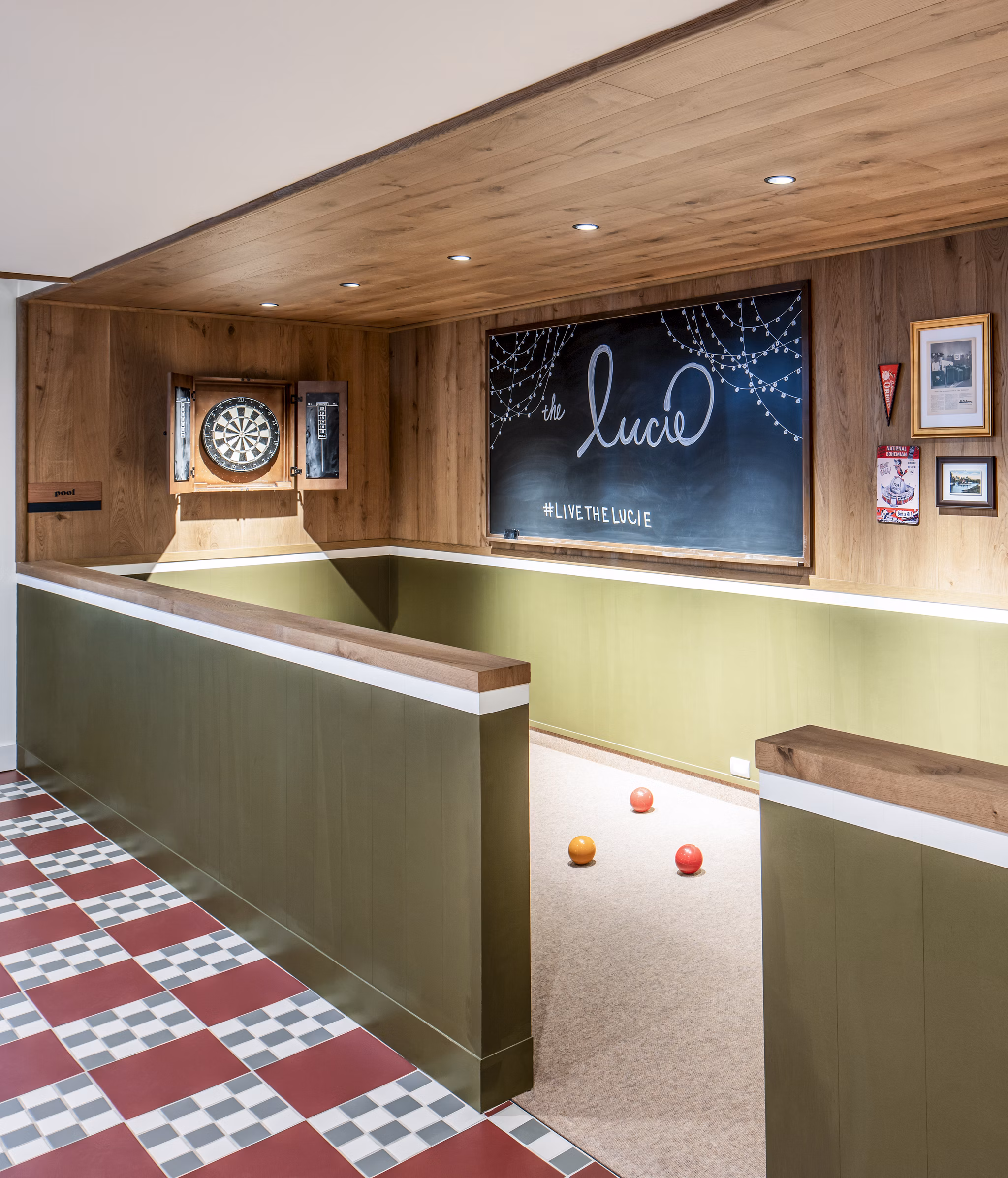 Indoor bocce ball court with dartboard and chalkboard wall at The Lucie luxury apartments