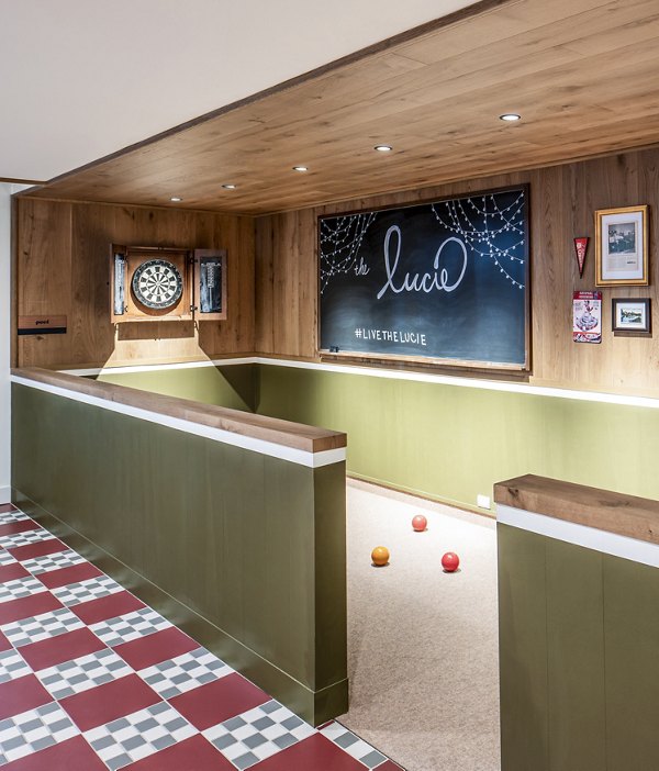 Indoor bocce ball court with dartboard and chalkboard wall at The Lucie luxury apartments