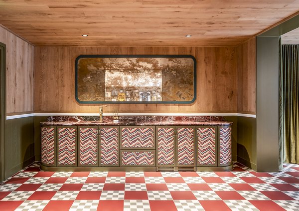 Retro-style kitchen featuring patterned cabinets and checkered floor tiles at The Lucie Apartments