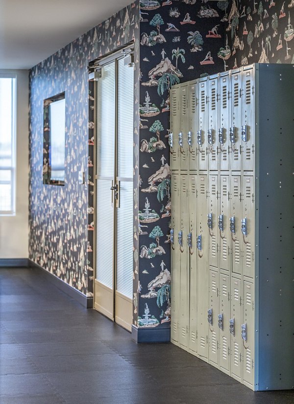 Hallway featuring lockers and patterned wallpaper at The Lucie Apartments