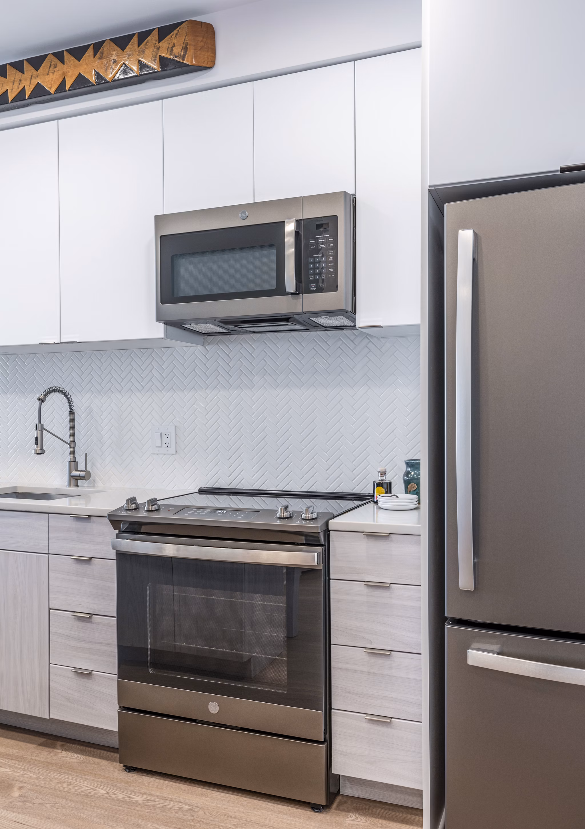 Sleek kitchen featuring stainless steel appliances and white cabinets at The Lucie Apartments