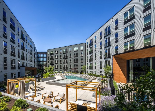 The Lucie Apartments: Courtyard with pool, seating areas, and lush greenery enhancing luxury apartment living