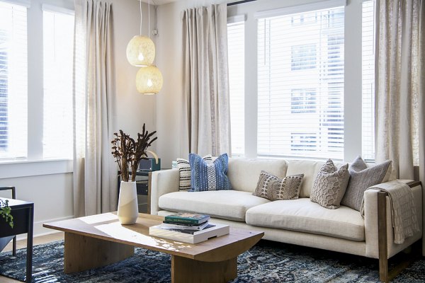 Modern living room with sleek furniture and natural lighting at Novel Cary Apartments